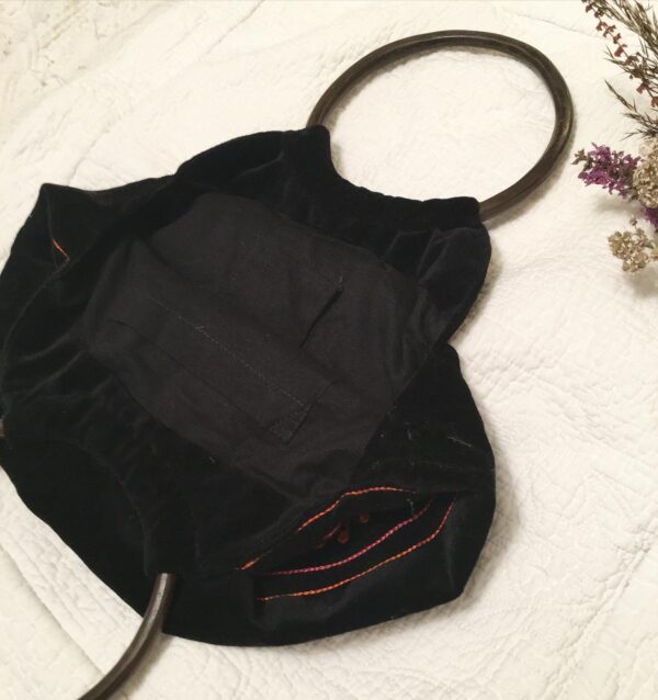 Black fabric lining of Indian embroidered bag with internal pockets